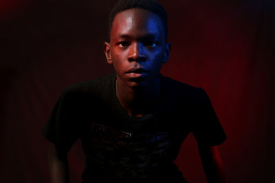 Portrait of young man standing against wall