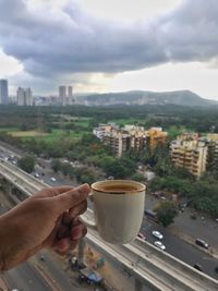 High angle view of coffee and cityscape against sky