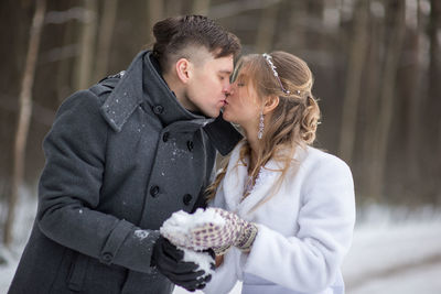 Couple with snow kissing during winter