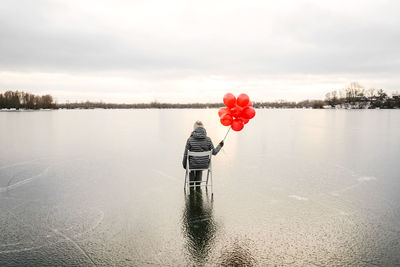 Red floating on water against sky