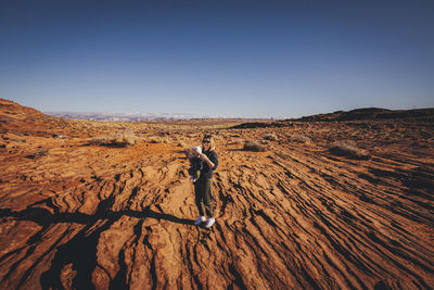 A woman with a child is standing near horseshoe bend, arizona