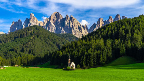 Panoramic view of green landscape and mountains against sky