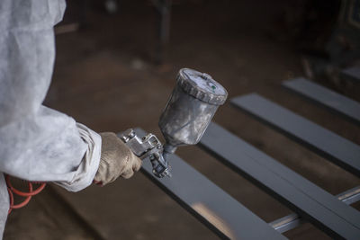 Cropped image of person holding spray paint