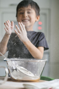 The child cooks in the kitchen. sifts the flour.