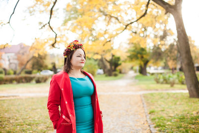 Portrait of smiling young woman standing against plants