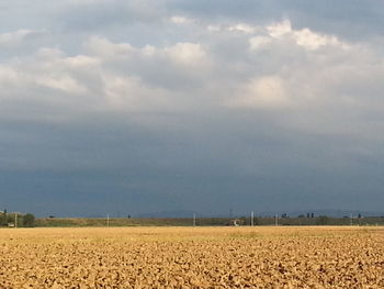 Scenic view of field against cloudy sky