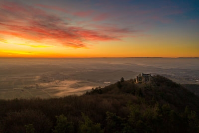 Scenic view of landscape against orange sky