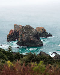 Rock formation in sea against sky