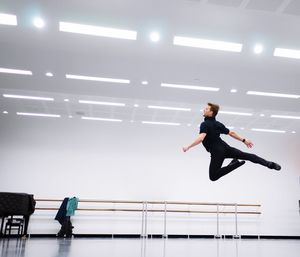 Full length of young dancer jumping in studio