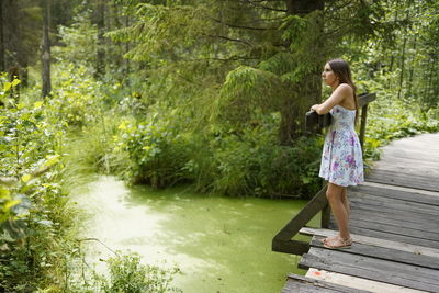 Side view of woman standing on bridge