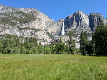 Scenic view of field and mountains against clear sky