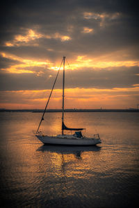 Silhouette sailboat on sea against sky during sunset