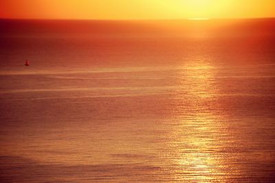 Scenic view of sea against orange sky