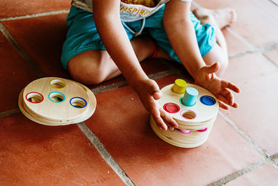 High angle view of boy playing with toy sitting on floor