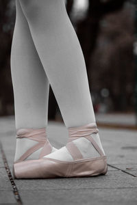 Low section of ballet dancer standing on footpath