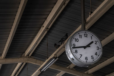 Low angle view of clock on ceiling of building