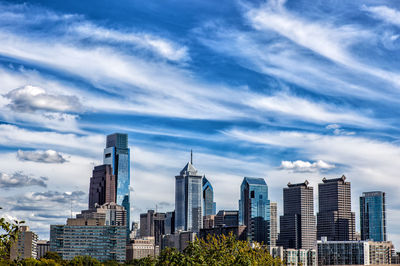 Buildings in city against cloudy sky