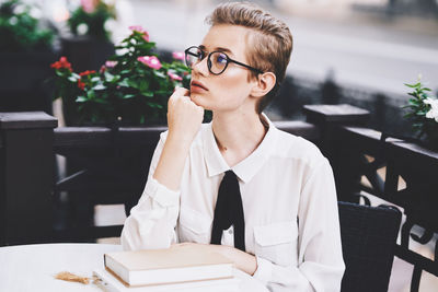 Portrait of mid adult woman looking away while sitting on table