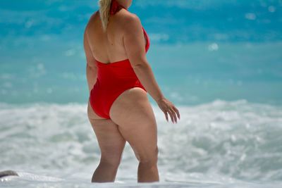 Midsection of woman standing in sea