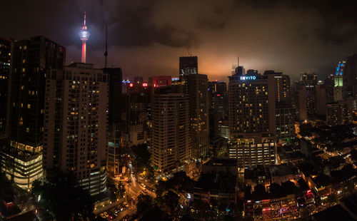 Illuminated menara kuala lumpur tower in city at night