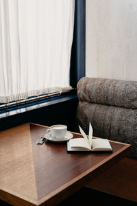 Close-up of a cup of coffee and a book on a table