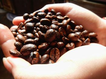 Cropped image of hands holding coffee beans