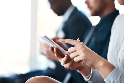 Midsection of businessman using mobile phone