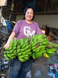 Portrait of smiling young woman standing by plants