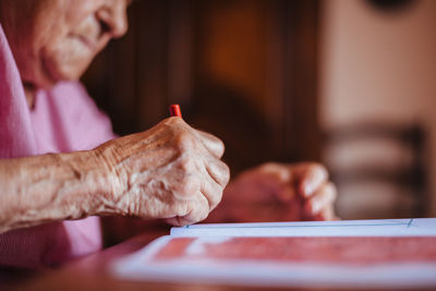 Midsection of man holding hands on table