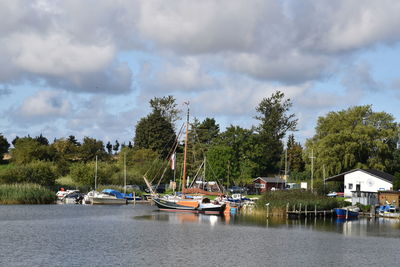 Sailboats moored in lake against sky