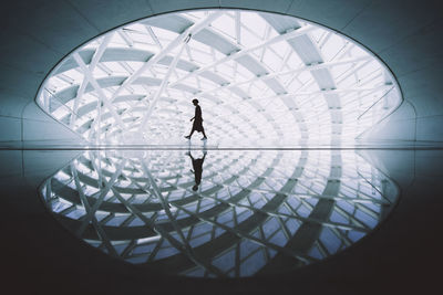 Low angle view of silhouette people walking in glass
