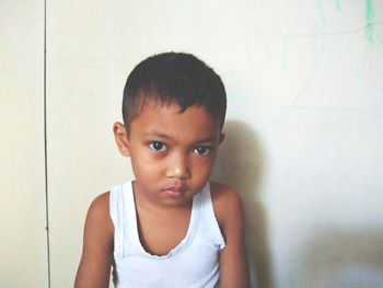Portrait of cute boy against wall