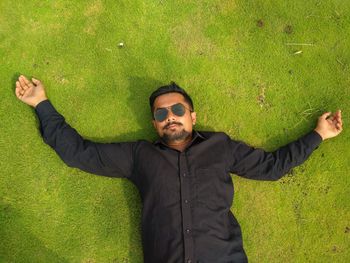 Young man wearing sunglasses standing on grass