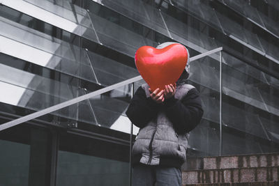 Midsection of person holding balloons