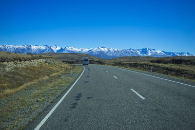 Road amidst landscape against clear blue sky