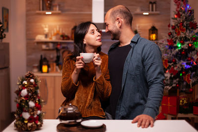 Couple standing in kitchen during christmas