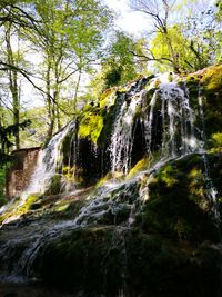Low angle view of waterfall against sky