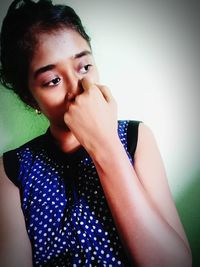 Portrait of beautiful young woman against wall