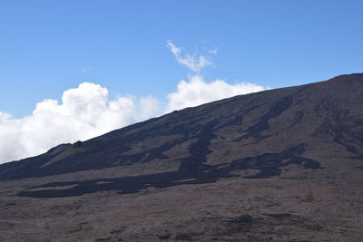 Scenic view of mountains against blue sky