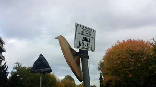 Low angle view of road sign against sky