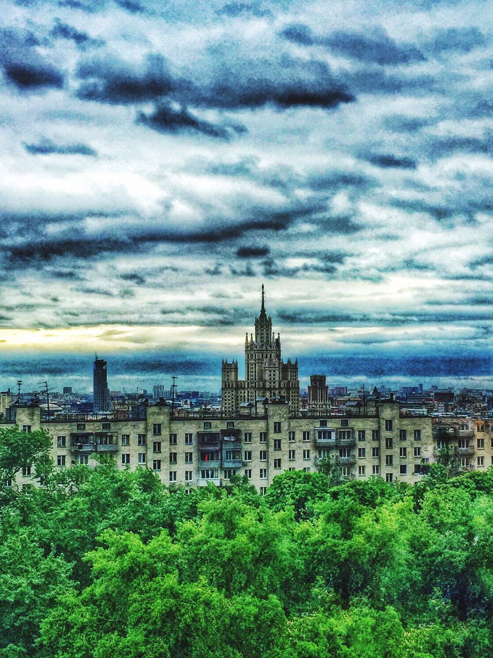 architecture, building exterior, built structure, sky, cloud - sky, city, cloudy, tree, cityscape, cloud, travel destinations, famous place, tower, residential district, residential building, capital cities, outdoors, day, green color, travel