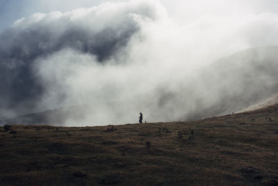 Man walking on mountain against sky