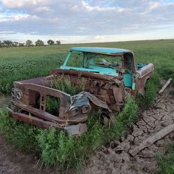 Abandoned truck on field against sky