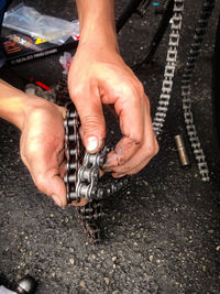 Cropped hand of man holding chain