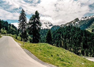 Road amidst trees against sky
