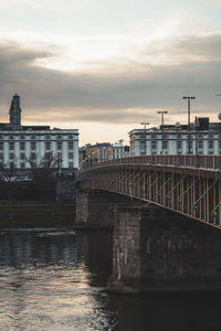 Bridge over river against cloudy sky