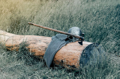 Metal chain mail, helmet and ax lie on wooden log. viking armor. historical film concept.