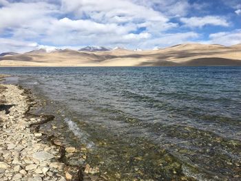 Scenic view of sea and mountains against sky