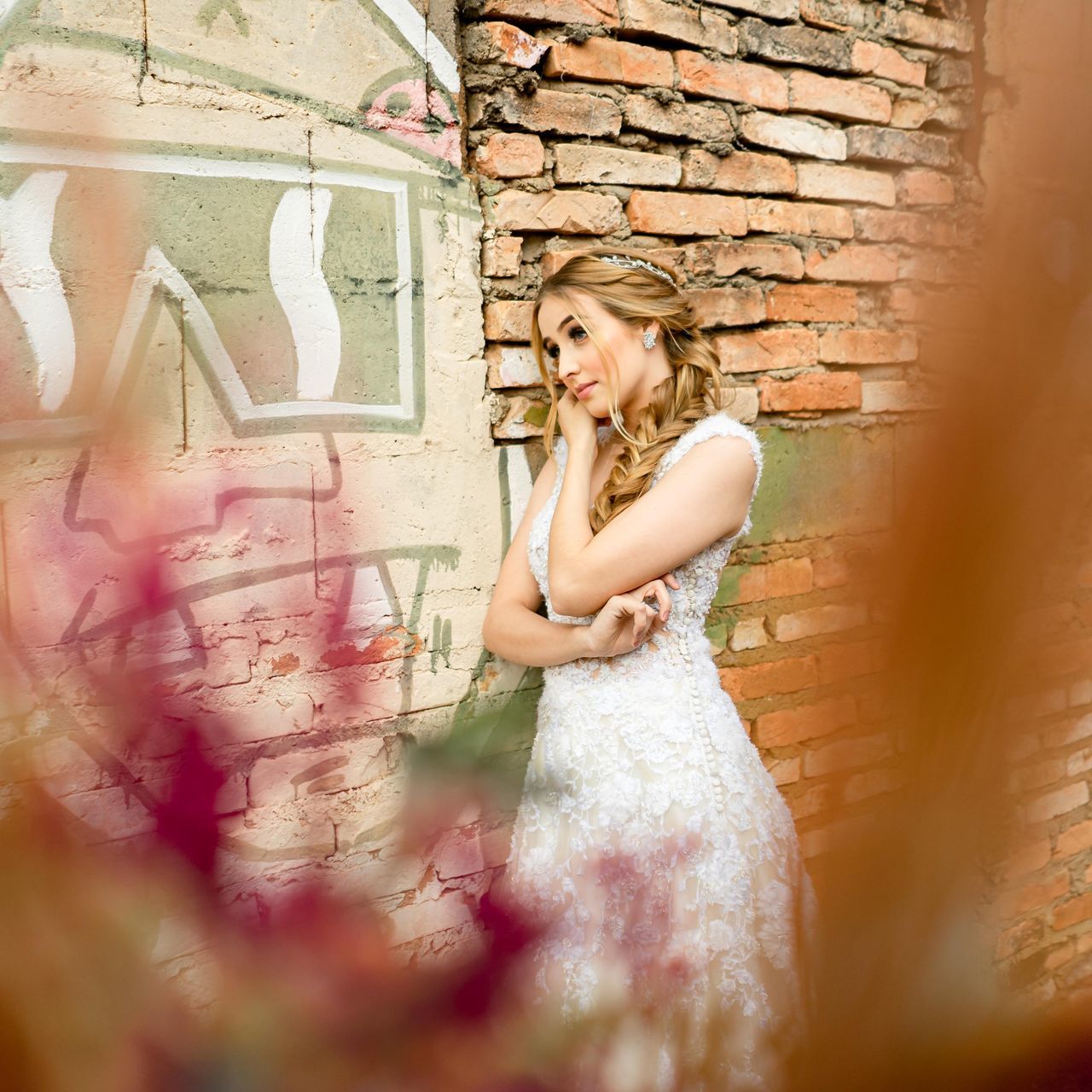 YOUNG WOMAN STANDING AGAINST GRAFFITI WALL