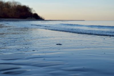 Scenic view of beach against sky at dusk